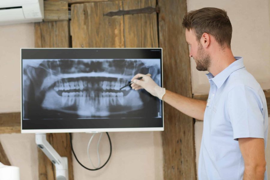 Zahnkonform Dr. Walker und Kollegen Entringen - Zahnarzt bei Auswertung eines Röntgenbildes