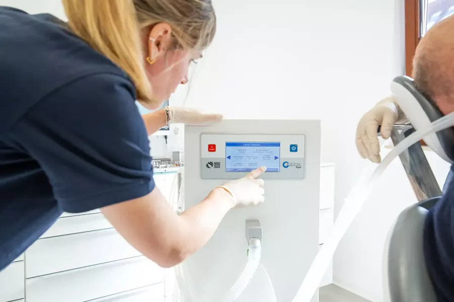 Eine Mitarbeiterin an einem zahntechnischen Gerät