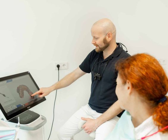 Zahnarzt Dr. Klein schaut mit Patientin digitale Ergebnisse des 3D-Scans an