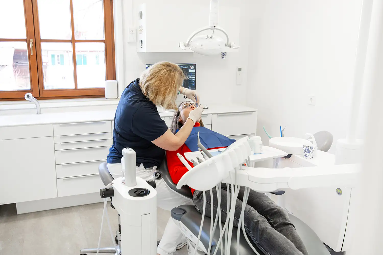 Parodotitis-Untersuchung einer Patientin durch eine Zahnärztin